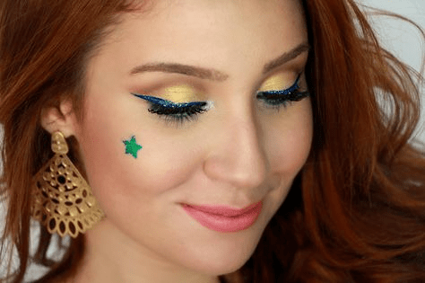  Maquiagem amarela com delineado azul e estrela verde 