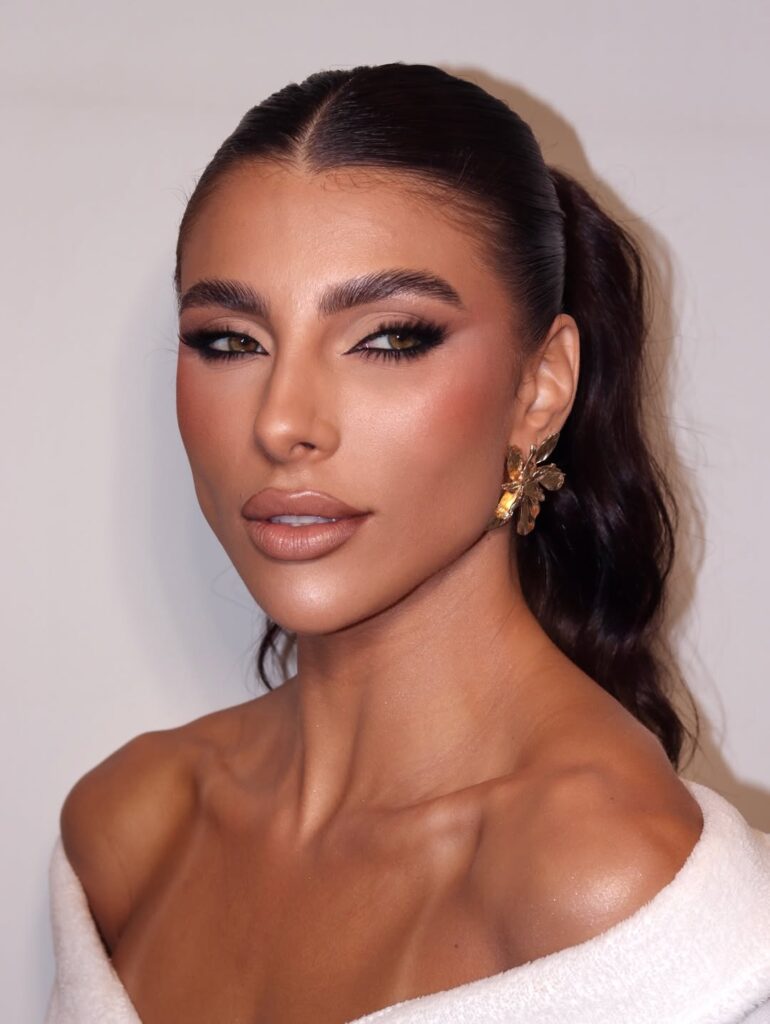 Mulher branca com maquiagem para formatura elegante.