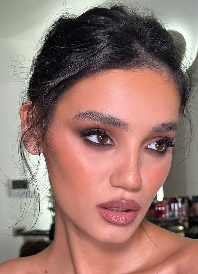 Mulher morena com maquiagem para formatura elegante.