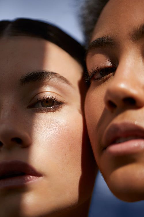 imagem com duas mulheres que representam os tipos de tom de pele e subtom de pele. uma mulher é branca e a outra é negra. a foto mostra parte do rosto delas.